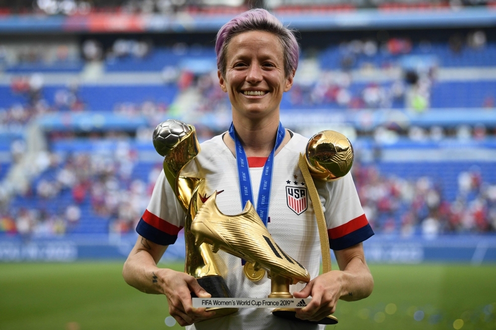 In this file photo taken on July 07, 2019, United States' forward Megan Rapinoe poses with the trophies after the France 2019 Women’s World Cup football final match between USA and the Netherlands, at the Lyon Stadium in Lyon, central-eastern France. While Megan Rapinoe is the leading candidate for the second ever women's Ballon d'Or, the holder of the men's award, Luka Modric, and the world's most expensive player Neymar missed out as France Football unveiled nominees in four categories on Monday. — AFP