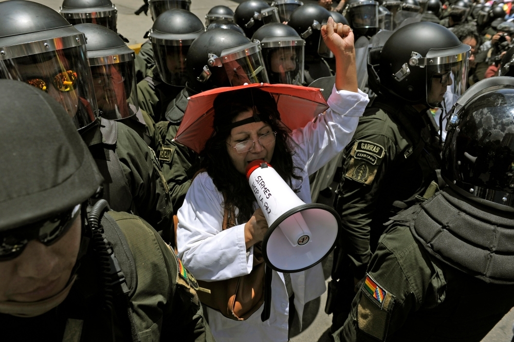  Health workers demonstrate outside the hotel where the Supreme Electoral Tribunal has its headquarters to count the election votes, in La Paz, on Tuesday. — AFP