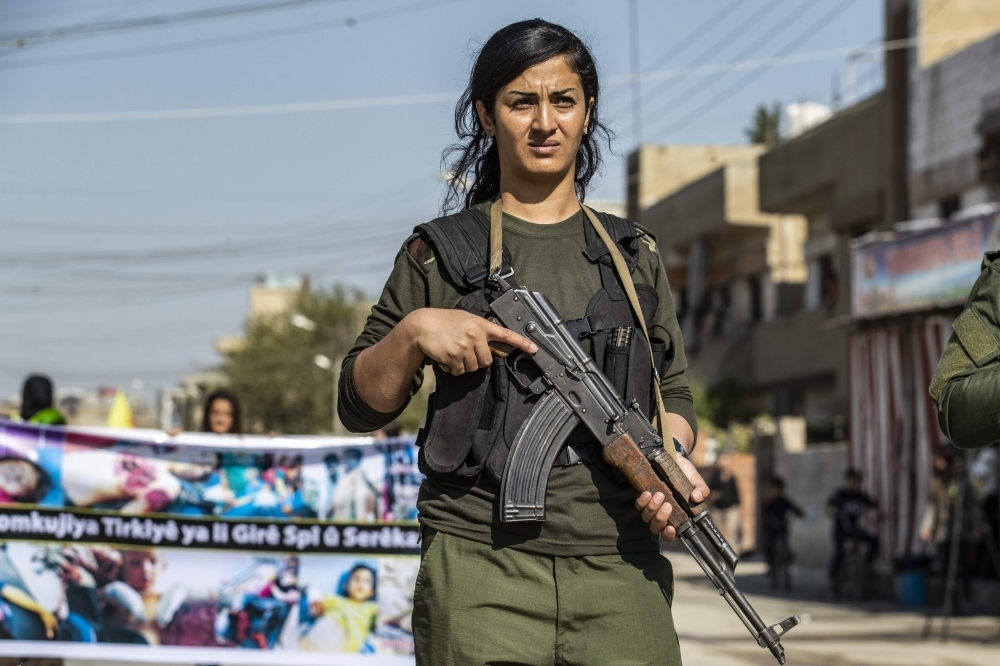 A member of the Kurdish Internal Security Force known as Asayesh stands guard during a protest against the Turkish assault on northeastern Syria, in the town of Qamishli, on Wednesday. — AFP