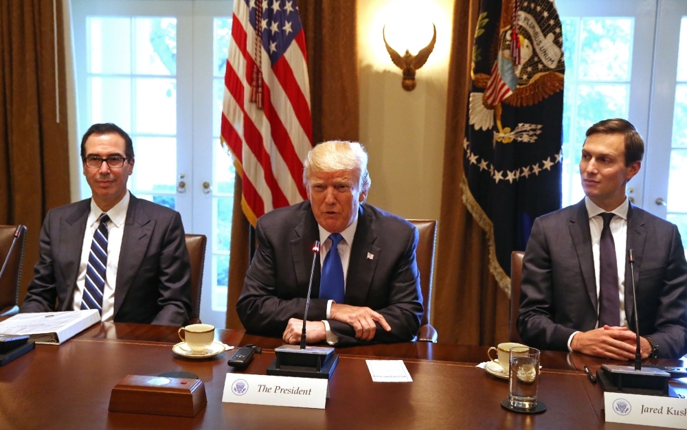 In this file photo taken on July 25, 2017, US President Donald Trump, flanked by his son-in-law Jared Kushner (R) and Treasury Secretary Steven Mnuchin, heads a meeting at the White house in Washington,DC. Mnuchin and presidential adviser Kushner will lead an American delegation to Saudi Arabia's annual financial conference, US media reported on Tuesday. — AFP