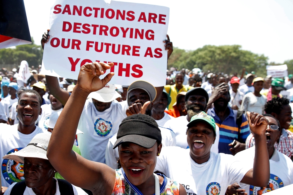 Government supporters chant slogans as they march against Western sanctions at a rally in Harare, Zimbabwe Friday. — Reuters