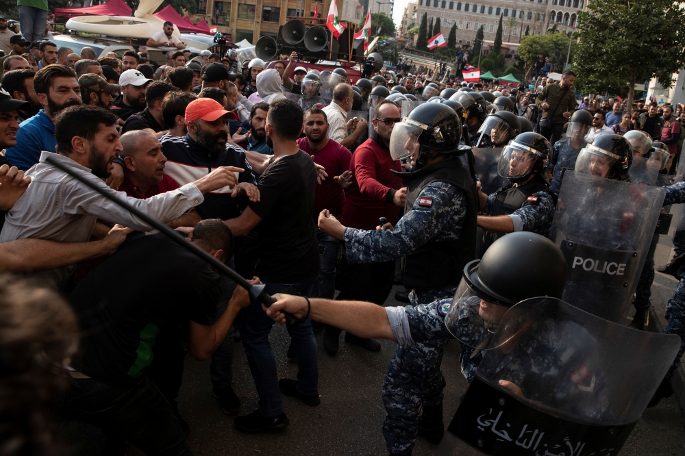 Riot police scuffle with Hezbollah supporters during ongoing anti-government protests in downtown Beirut, Lebanon, on Friday. — Reuters