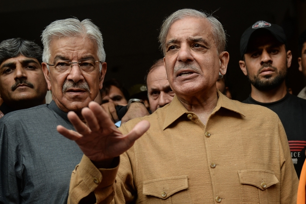 Shahbaz Sharif, right, brother of Pakistani former Prime Minister Nawaz Sharif talks with media representatives as he leaves from the High court in Lahore, Pakistan, on Friday. — AFP