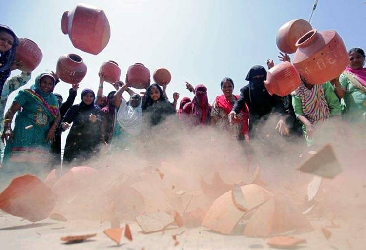 Women throw earthen pitchers onto the ground in protest against a shortage of drinking water outside the municipal corporation office in Ahmedabad, India, May 16, 2019. — Reuters