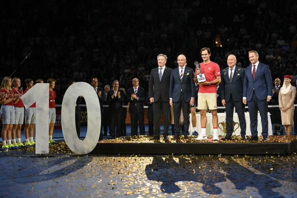 Swiss Roger Federer (C) celebrates with his trophy after his 10th victory at the Swiss Indoors tennis tournament in Basel, on Sunday. — AFP