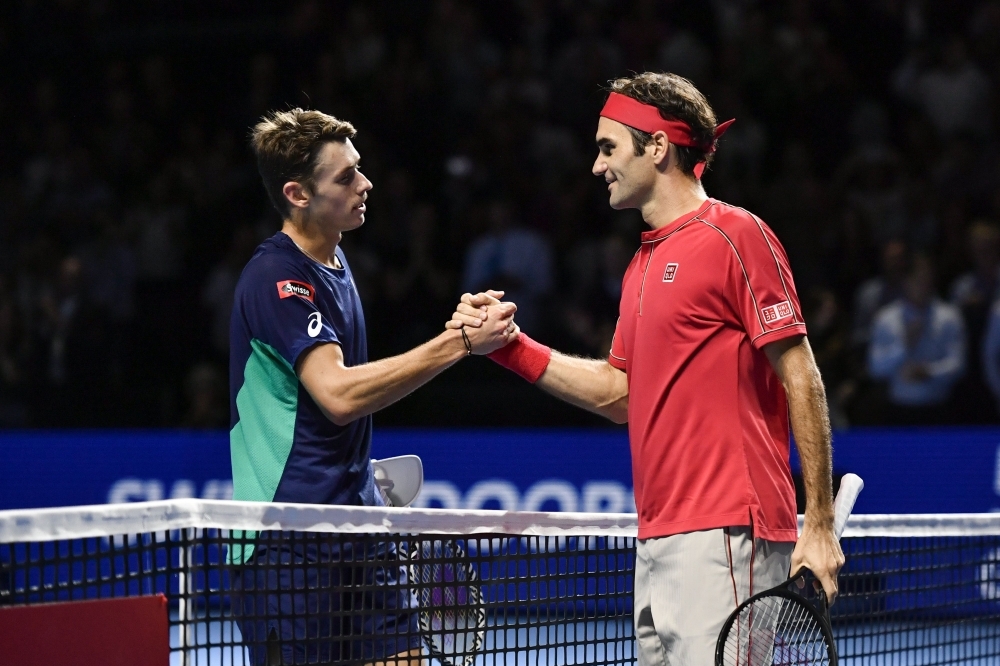 Swiss Roger Federer (C) celebrates with his trophy after his 10th victory at the Swiss Indoors tennis tournament in Basel, on Sunday. — AFP