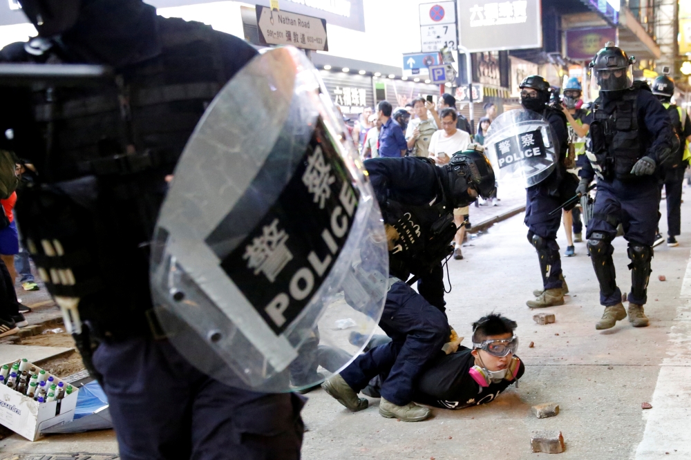 An anti-government protester is detained by riot police during a protest at Mong Kok in Hong Kong, China, on Sunday. — Reuters