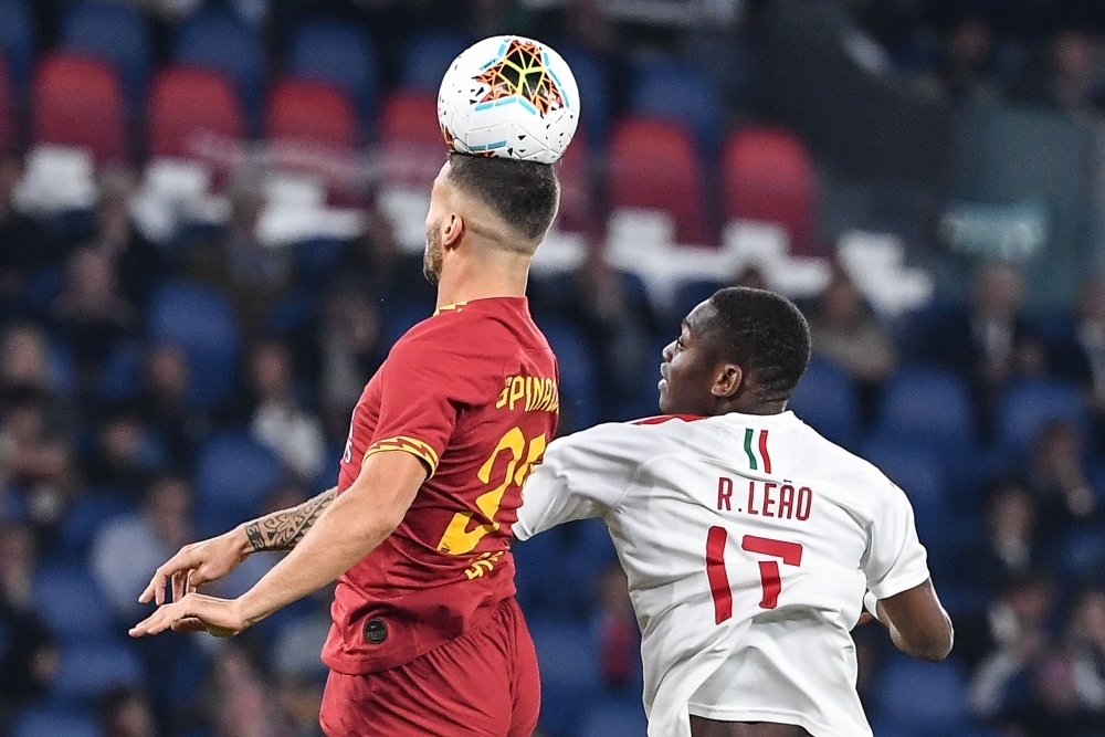 AS Roma's Italian defender Leonardo Spinazzola (L) jumps for the ball with AC Milan's Portuguese forward Rafael Leao, during the Italian Serie A football match between AS Roma and AC Milan at the Olympic stadium in Rome, on Sunday. — AFP