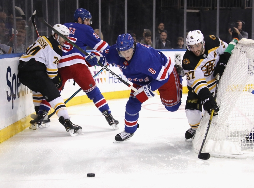 Jacob Trouba (8) of the New York Rangers and Patrice Bergeron (37) of the Boston Bruins battle for the puck during the first period at Madison Square Garden in New York City, on Sunday. — AFP