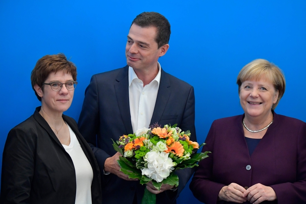 The leader of Germany's conservative Christian Democratic Union (CDU) party Annegret Kramp-Karrenbauer, left, the CDU's top co-candiate for Thuringian state elections Mike Mohring, center, and German Chancellor Angela Merkel pose during a leadership meeting of the CDU at their headquarters in Berlin on Monday, one day after regional elections in Thuringia. — AFP