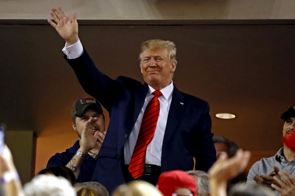 President Donald Trump waves to the crowd during game five of the 2019 World Series between the Houston Astros and the Washington Nationals at Nationals Park in Washington on Sunday. — Reuters