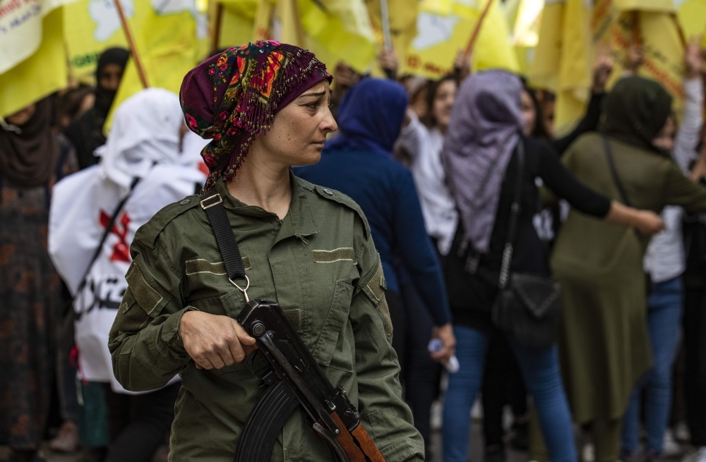 A member of the Kurdish internal security services known as Asayish stands guard during a demonstration by Syrian Kurds against the Turkish assault on northeastern Syria and in support of the Syrian Democratic Forces (SDF), in Syria's northeastern city of Qamishli on Monday. — AFP