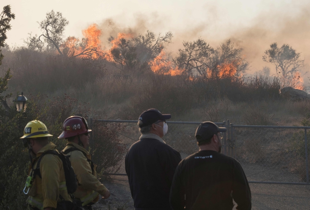 Flames cross the driveway of the Reagan Library as firefighters battle to protect it from the Easy Fire in Simi Valley, California on October 30, 2019.  Firefighters in California battled a new fast-moving blaze on Wednesday that threatened the Ronald Reagan Presidential Library, as rare 