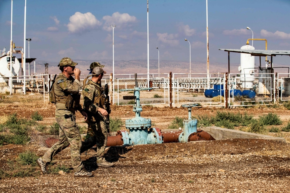 US soldiers walk in the Syrian northeastern town of Qahtaniyah on the border with Turkey on Thursday. — AFP