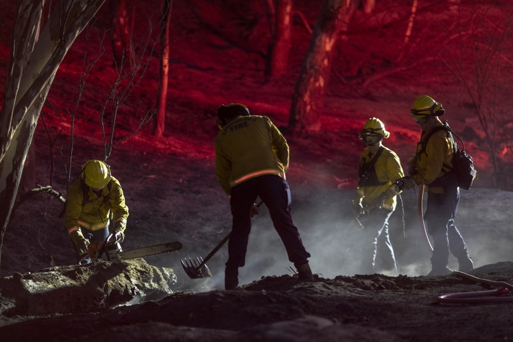 Firefighters work into the night at the Easy Fire near Simi Valley, California, on Wednesday. — AFP