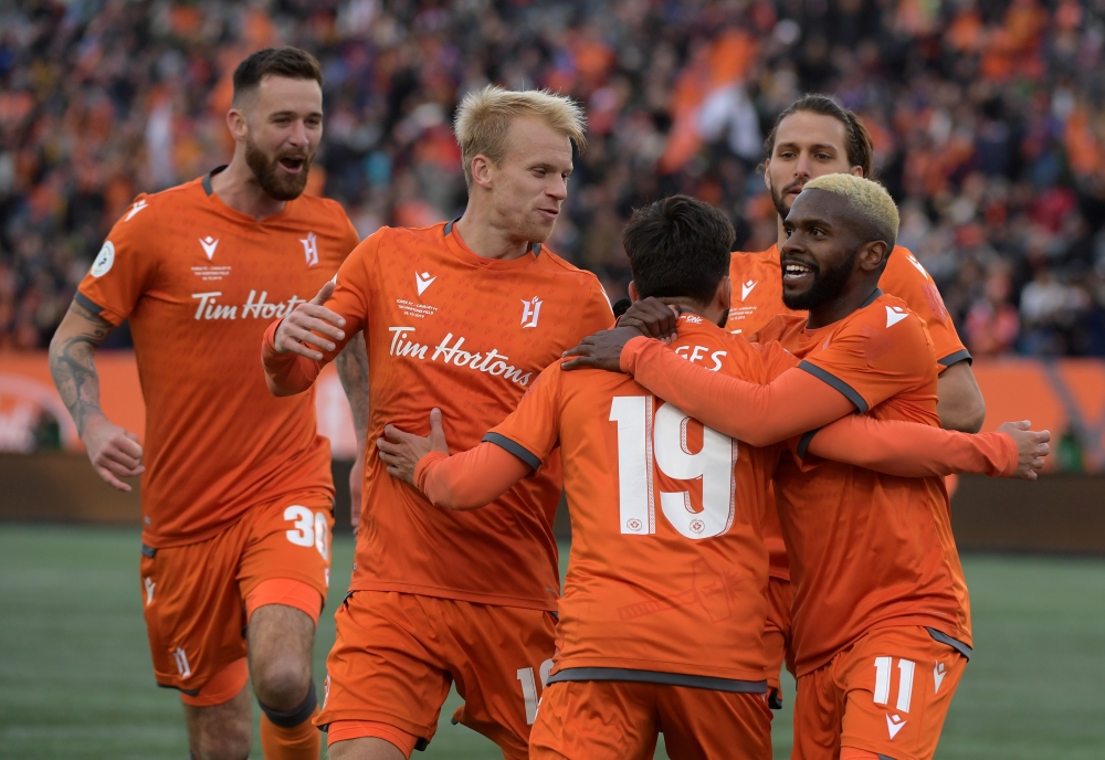 Forge FC midfielder Tristan Borges (19) is greeted by forward Christopher Nanco (11) and midfielder Kyle Bekker (10) and defenders David Edgar (30) and Giuliano Frano (8) after scoring against Cavalry FC in the first half of a Canadian Premier League soccer final match at Tim Hortons Field in this file photo. — Reuters