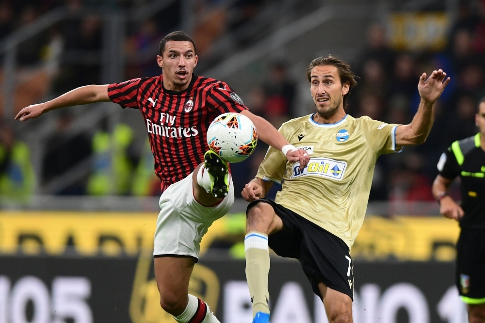 AC Milan's Algerian defender Ismael Bennacer fights for the ball with Spal's Italian midfielder Simone Missiroli during the Italian Serie A football match between AC Milan and Spal on Thursday at the San Siro stadium in Milan. — AFP