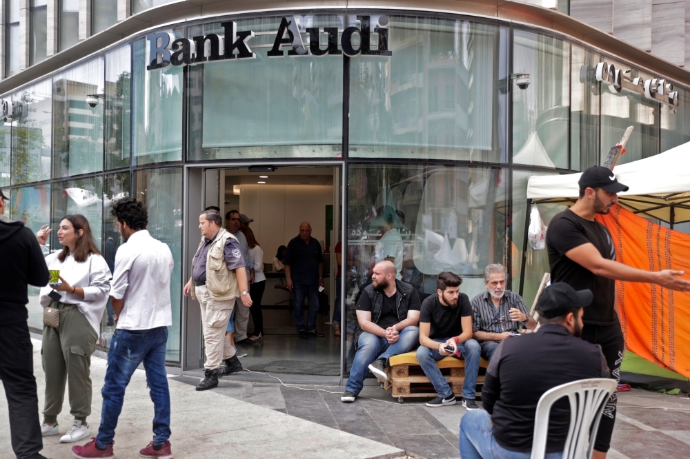 Lebanese protesters camp at the entrance of a bank in Beirut on Friday. — AFP