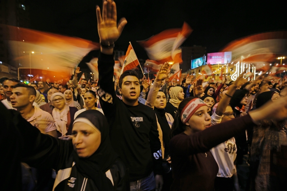 Lebanese protesters wave flags and shout slogans during an anti-government demonstration at Al-Nour Square in the northern port city of Tripoli on Saturday. -AFP