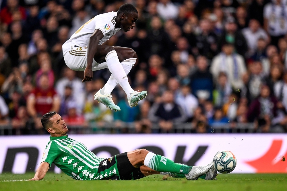 Real Madrid's French defender Ferland Mendy jumps over Real Betis' Moroccan defender Zouhair Feddal during the Spanish League football match between Real Madrid CF and Real Betis at the Santiago Bernabeu stadium in Madrid, on Saturday. — AFP