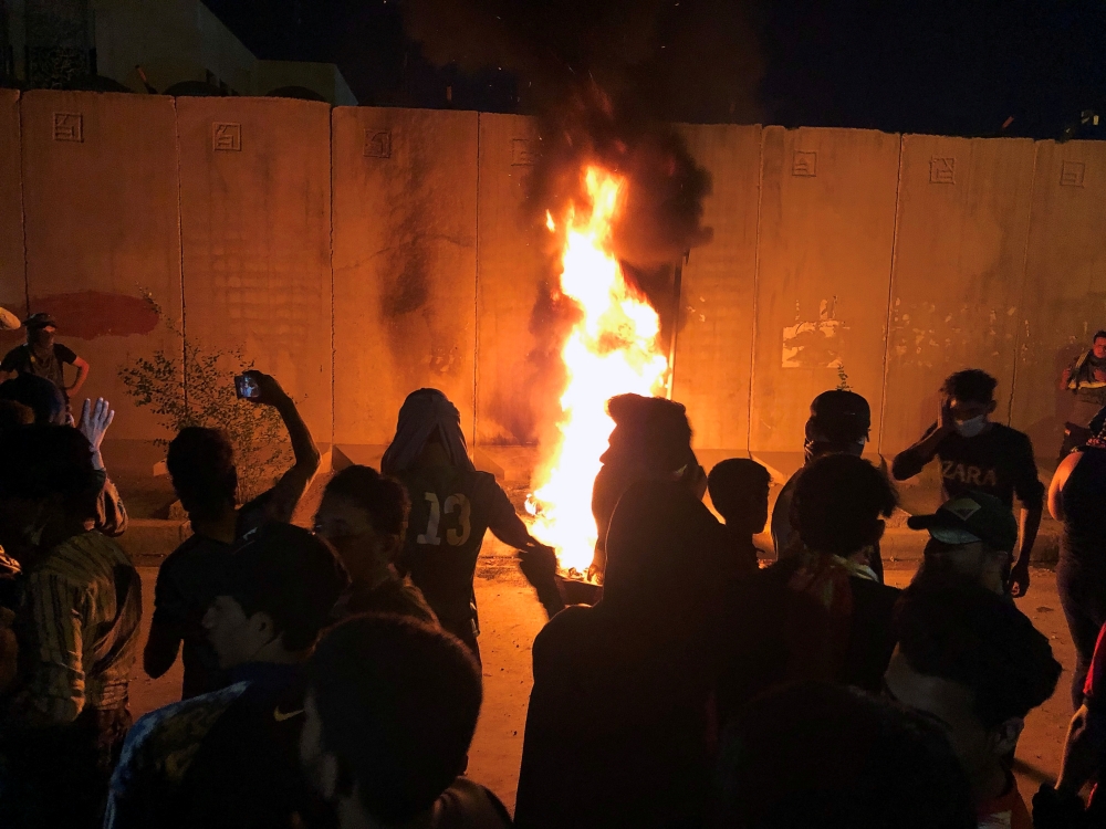 Demonstrators set fire in front of the Iranian consulate, as they gather during ongoing anti-government protests in Kerbala, Iraq on Sunday. -Reuters