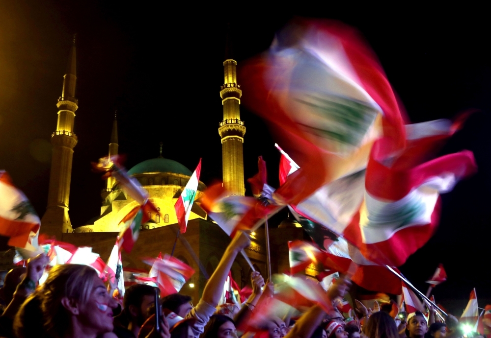 Lebanese protesters wave the national flag during an anti-government demonstration in downtown Beirut, on Sunday. -AFP 