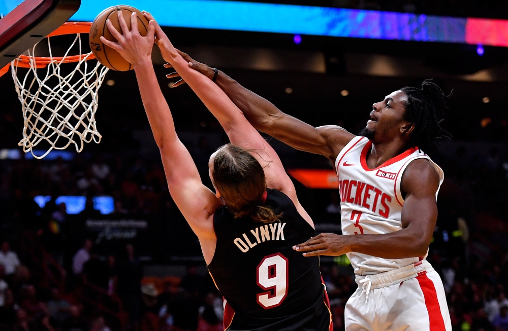 Miami Heat forward Kelly Olynyk (9) is defended by Houston Rockets guard Chris Clemons (3) at the basket during the second half at American Airlines Arena, Miami, FL, USA, on Sunday. — Reuters