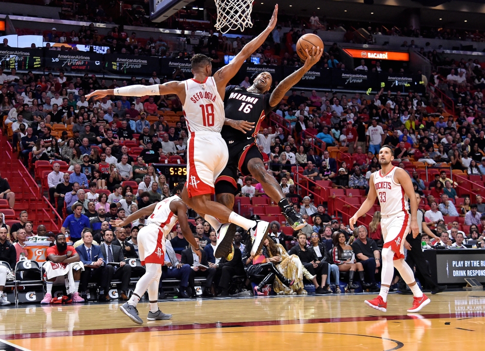 Miami Heat forward Kelly Olynyk (9) is defended by Houston Rockets guard Chris Clemons (3) at the basket during the second half at American Airlines Arena, Miami, FL, USA, on Sunday. — Reuters