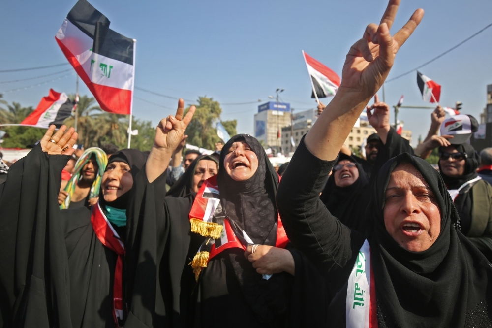 Iraqi women chant slogans and wave national flags as they take part in a protest in the capital Baghdad's Tahrir square during ongoing anti-government protests on Monday. — AFP