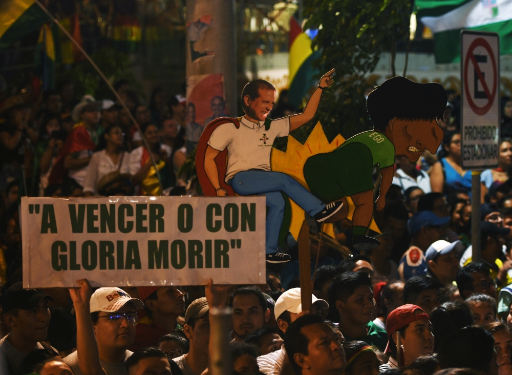 Demonstrators hold cutouts of Luis Fernando Camacho, President of Civic Comittee of Santa Cruz, and Bolivia's President Evo Morales and a sign that reads 