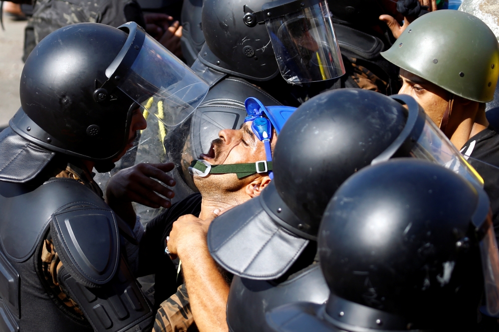Demonstrators scuffle with members of Iraqi security forces during one of the ongoing anti-government protests in Baghdad on Wednesday. -Reuters