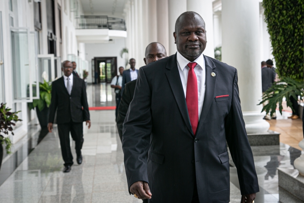 South Sudan's opposition leader Riek Machar, right, arrives for talks on South Sudan's proposed unity government at State House in Entebbe, Uganda, on Thursday. — AFP