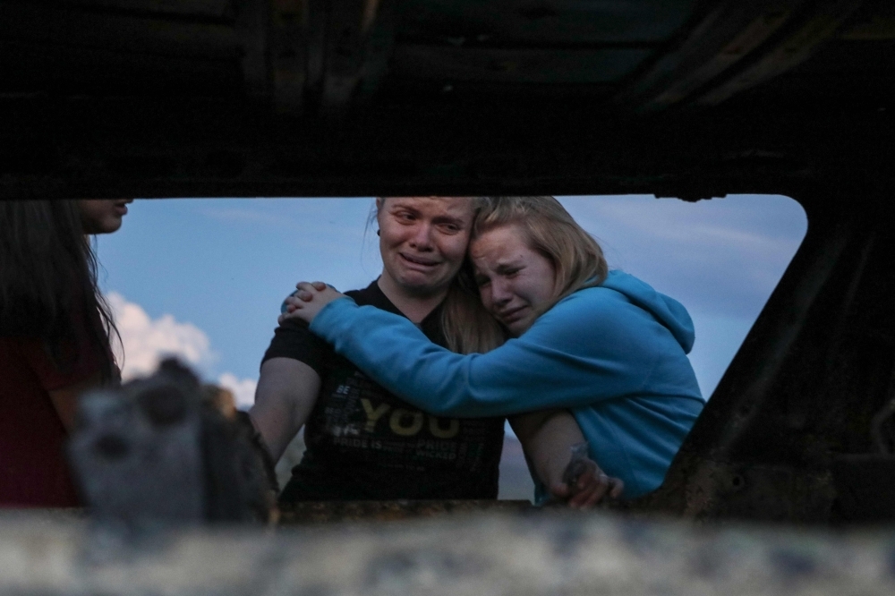 Members of the Lebaron family mourn while they watch the burned car where part of the nine murdered members of the family were killed and burned during an gunmen ambush on Bavispe, Sonora mountains, Mexico, in this Nov. 5, 2019 file photo. — AFP