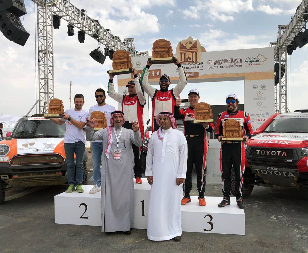 The top three in AlUla-Neom Rally are seen on the podium.