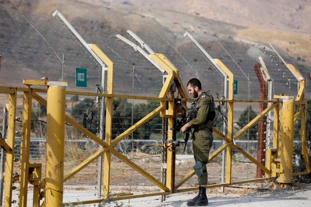 An Israeli soldier closes a border gate on the Israeli side of the border at the Jordan Valley site of Naharayim, also known as Baqura in Jordan, east of the Jordan river on Sunday. -AFP