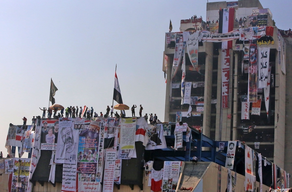 Iraqi protesters gather atop the abandoned 