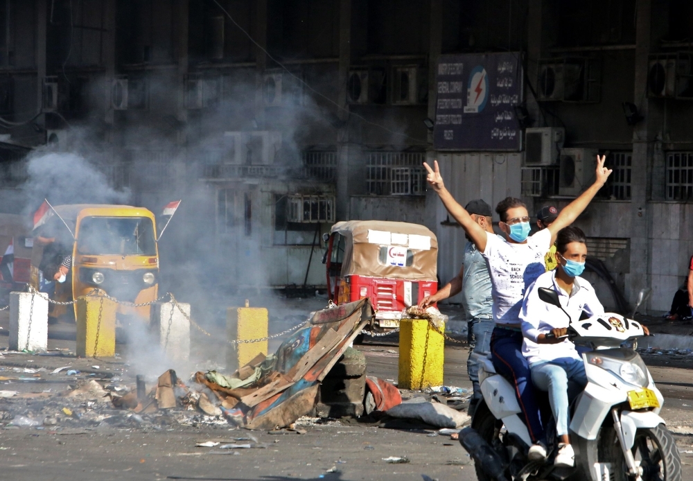 Iraqi protesters gather atop the abandoned 