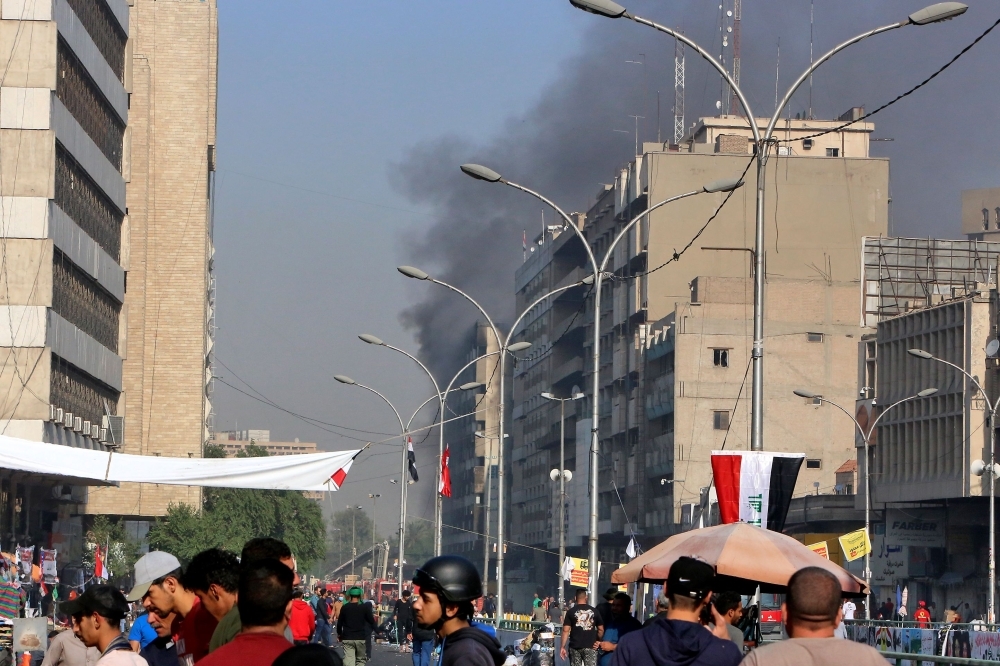 Iraqi protesters gather atop the abandoned 