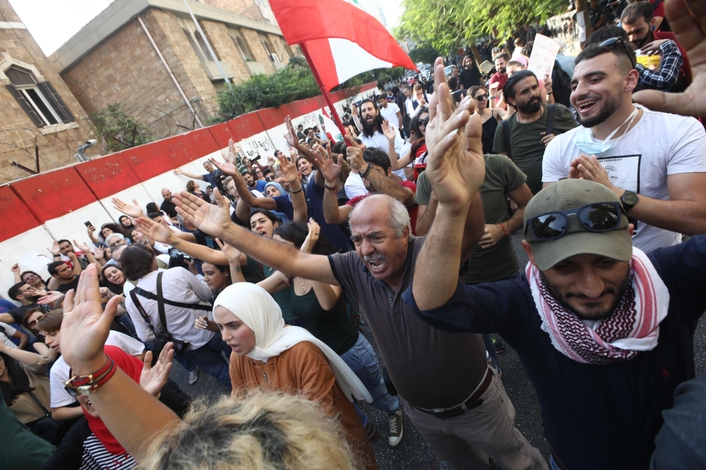 A Lebanese demonstrator raises an old identity card during a march entitled 