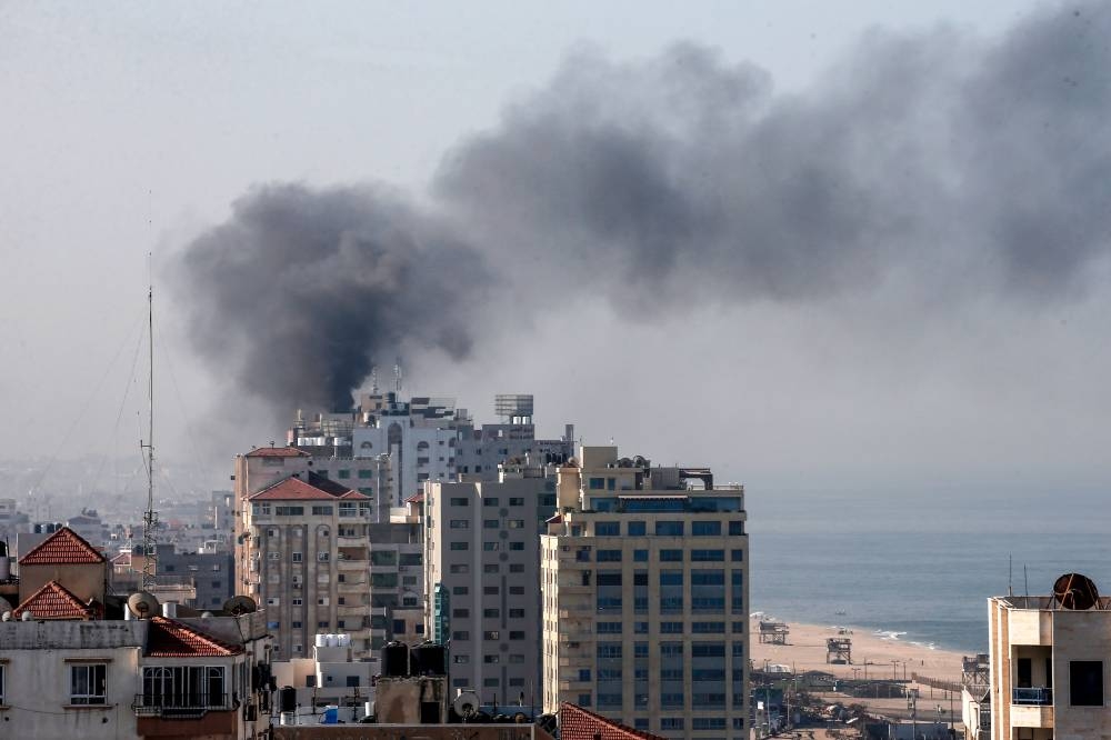 Smoke billows from a building in Gaza City on Tuesday, after an Israeli airstrike killed a commander of Palestinian militant group and prompted retaliatory rocket fire from the Palestinian enclave. -AFP