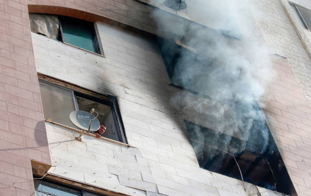 Smoke billows from a building in Gaza City on Tuesday, after an Israeli airstrike killed a commander of Palestinian militant group and prompted retaliatory rocket fire from the Palestinian enclave. -AFP