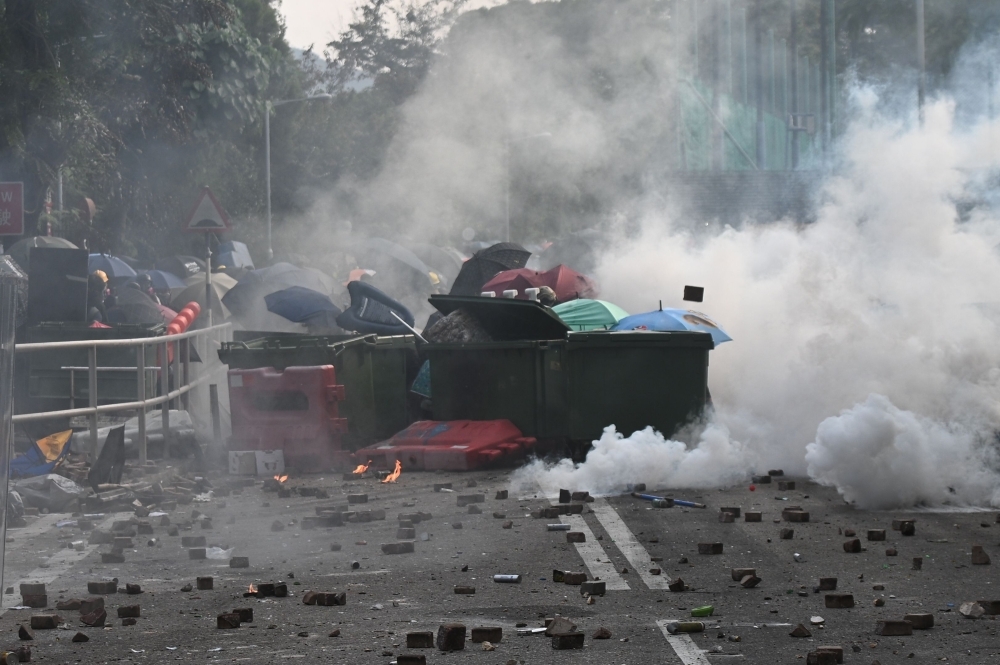 Police fire tear gas towards protesters at the Chinese University of Hong Kong (CUHK), in Hong Kong on Tuesday. -AFP 