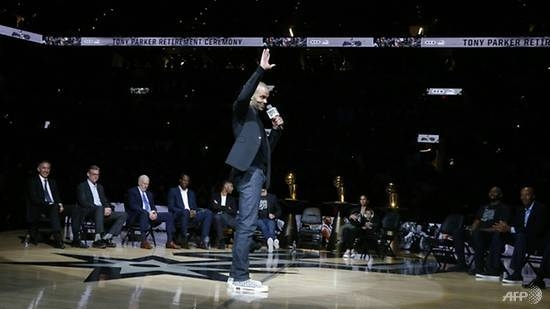 Retired San Antonio Spurs star guard Tony Parker waves to spectators during a ceremony Monday at which the NBA club retired his number nine jersey. — AFP