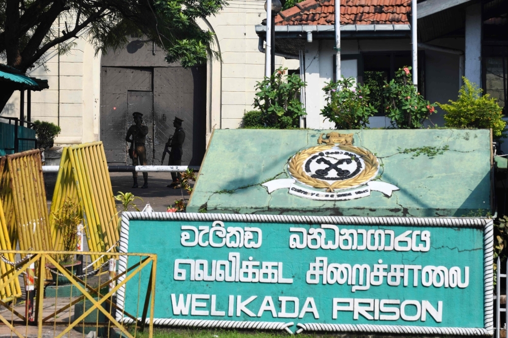 Special Task Force (STF) soldiers stand guard near the Welikada prison in Colombo on Tuesday, as inmates protest the pardon for a man who murdered a Swedish teenager in 2005. — AFP