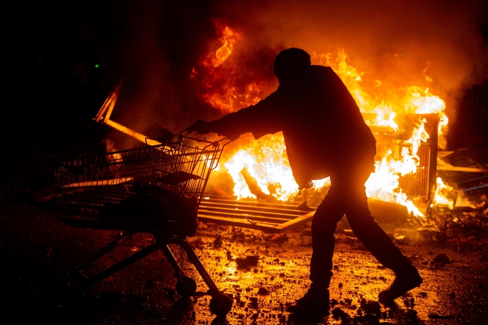 Demonstrators clash with security forces during a protest against the government of Sebastian Pinera in Santiago on Tuesday. -AFP  