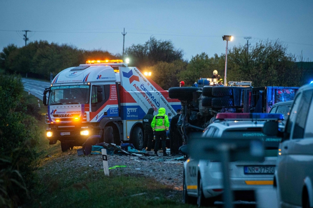 The emergency services work at the scene of collision between a public bus and a truck near the village of Malanta on the outskirts of the city of Nitra, western Slovakia, on Wednesday. — AFP