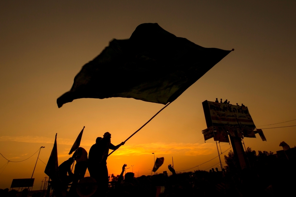 Iraqi protesters wave a flag during a demonstration during ongoing anti-government demonstrations in the southern city of Basra on Wednesday. — AFP