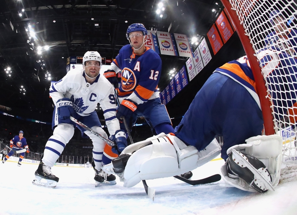 John Tavares No. 91 of the Toronto Maple Leafs and Josh Bailey No. 12 of the New York Islanders battle for position during the second period at NYCB Live's Nassau Coliseum on Wednesday in Uniondale, New York. The Islanders defeated the Maple Leafs 5-4. — AFP