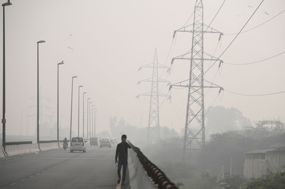 Commuters drive along a motorway under heavy smog conditions in New Delhi on Thursday. — AFP