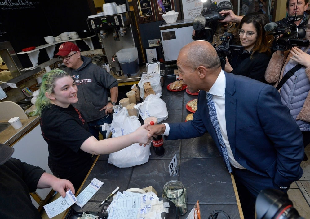 Former Massachusetts Governor Deval Patrick, US Democratic Presidential hopeful, orders lunch and greets locals at the Bridge Cafe on Thursday in Manchester, New Hampshire. — AFP
